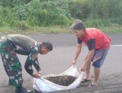 Wujud Nyata Pengabdian TNI, Koramil 04/Dimembe Gotong-Royong Bersama Masyarakat Bersihkan Jalan Utama